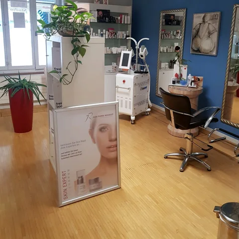 Salonbereich mit Stylingstuhl und grossen Fenstern