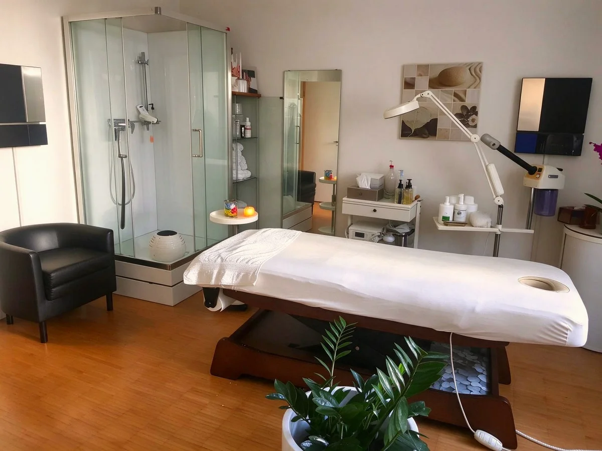 Bequeme Massageliege im hellen Behandlungsraum